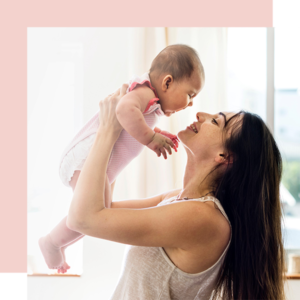 A nanny is playing with a baby.